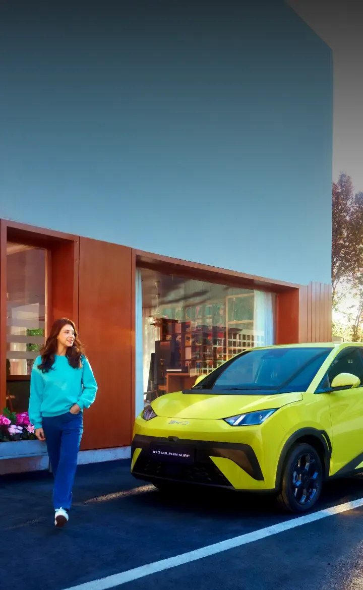 Novo BYD Dolphin Surf estacionado com mulher a passar à frente do carro