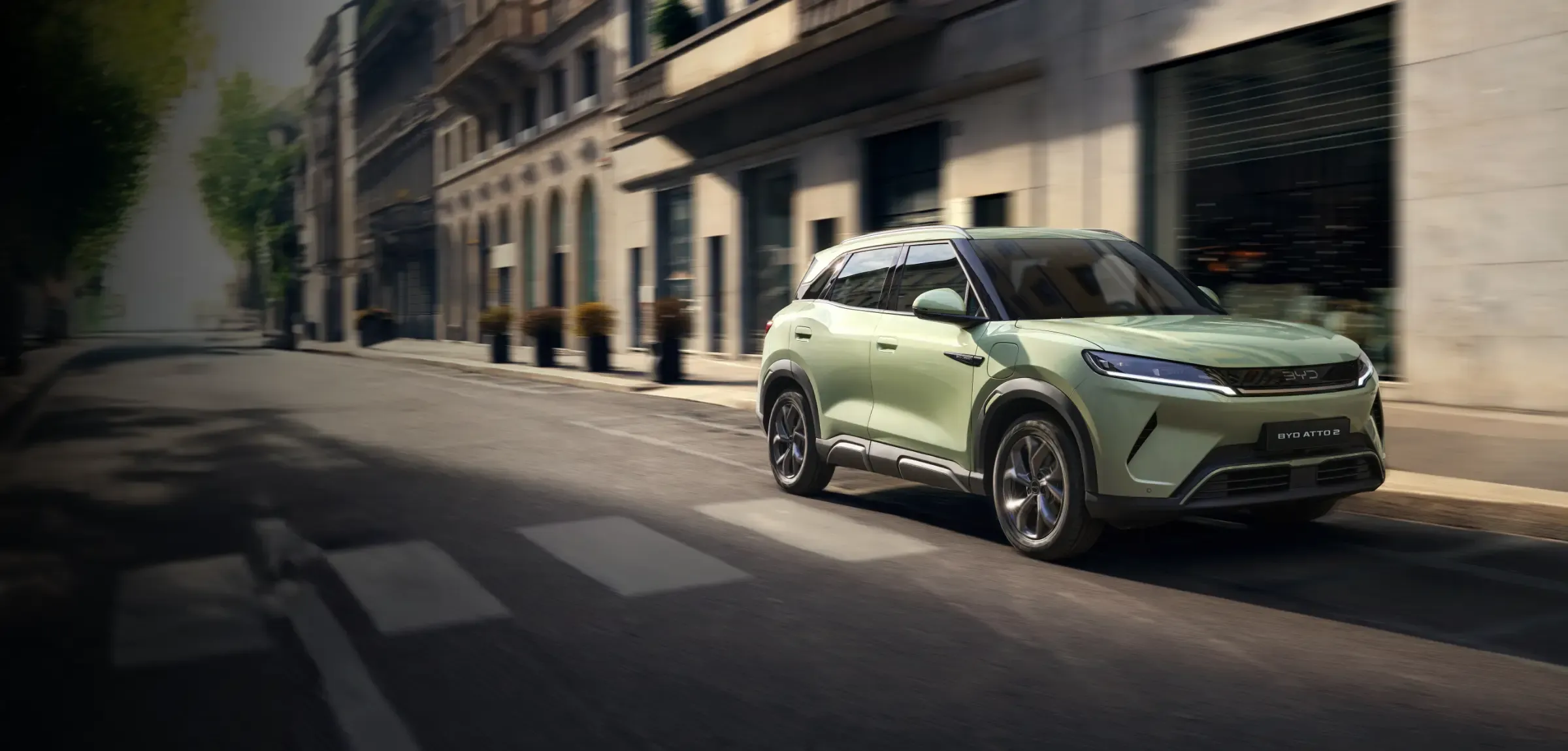 Um BYD ATTO 2 de cor verde circula na cidade