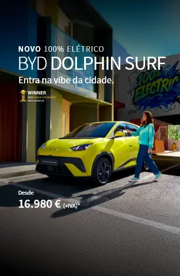 BYD DOLPHIN SURF parado na estrada com grafitis atrás e pessoa a abrir o carro