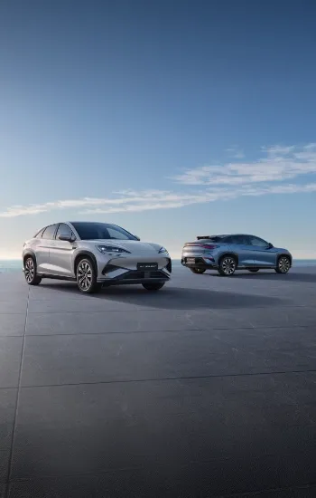 Dois BYD's SEALION 7 parados numa plataforma com vista para o mar 