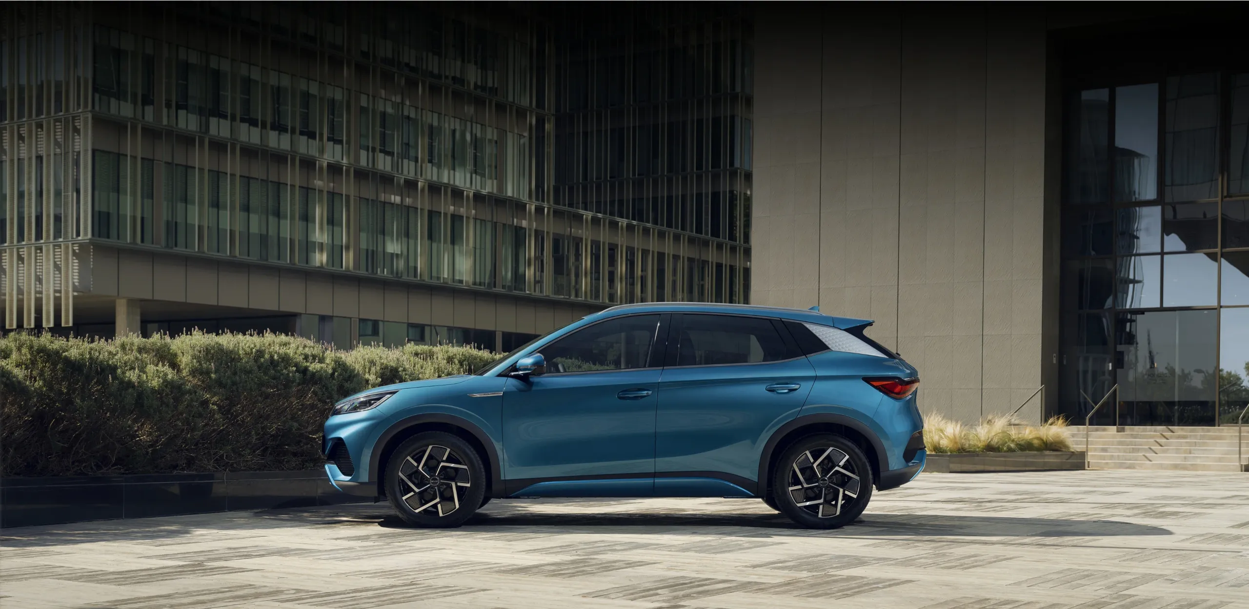 BYD ATTO 3 estacionado de perfil evidenciando suas linhas desportivas
