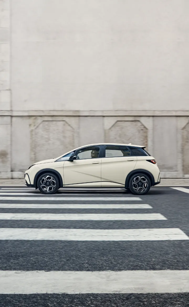 BYD DOLPHIN circula numa estrada urbana com uma mulher ao volante