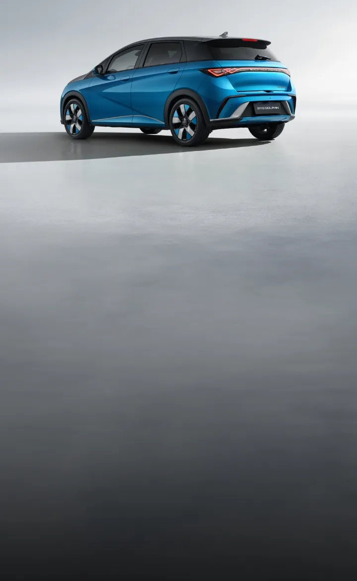 Visão lateral e traseira do BYD DOLPHIN azul estacionado num espaço neutro