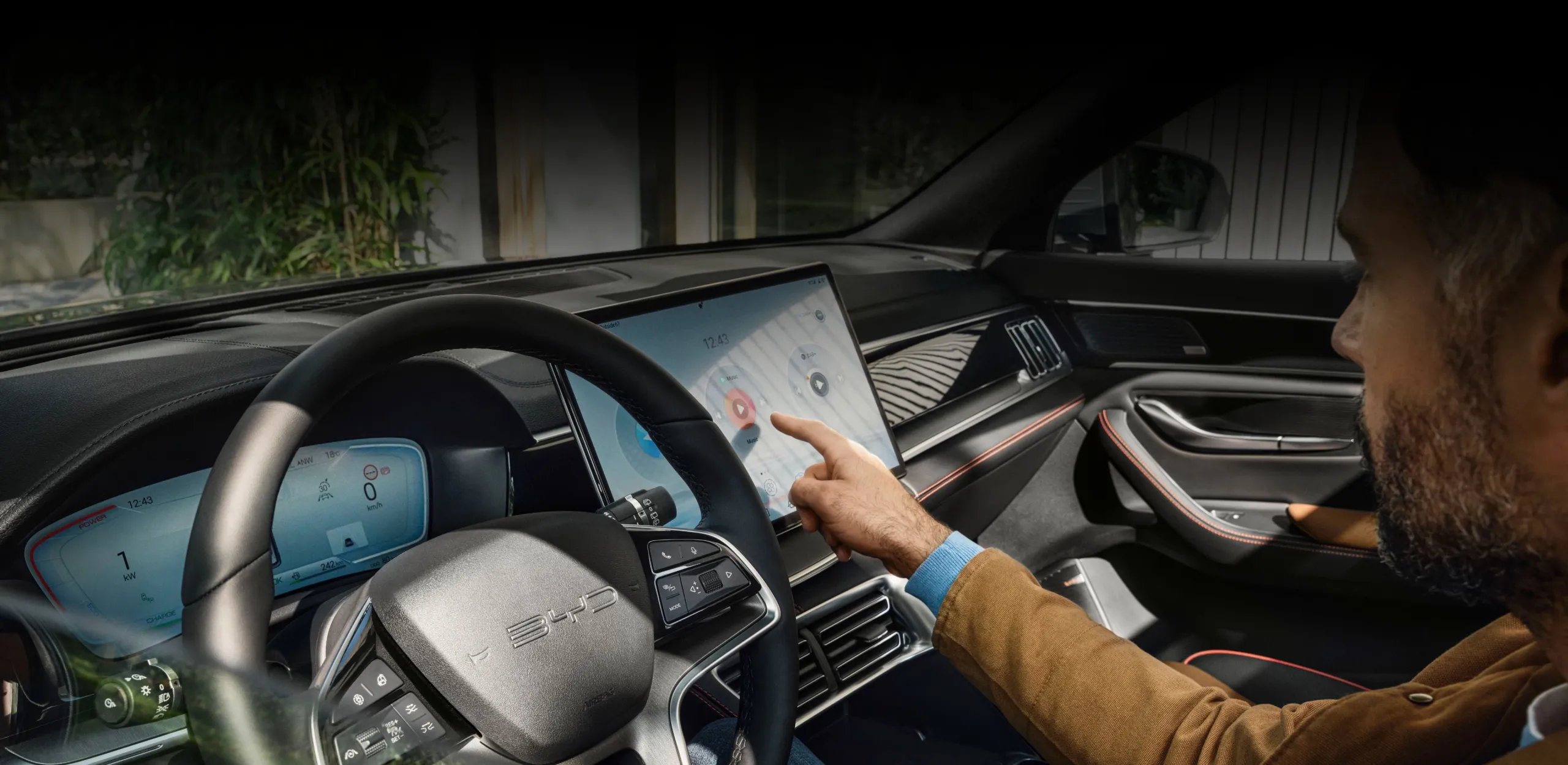 Condutor no cockpit do BYD SEAL U DM-i digita algo no ecrã LCD de infoentretenimento