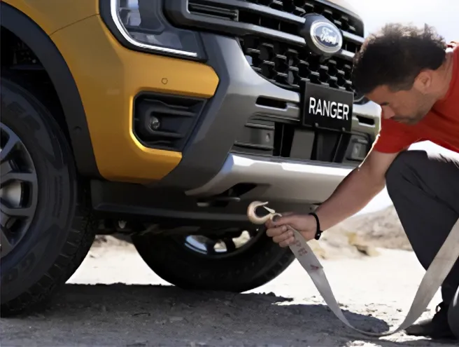 Pessoa a colocar uma corda na parte frontal da Ranger para ser rebocada