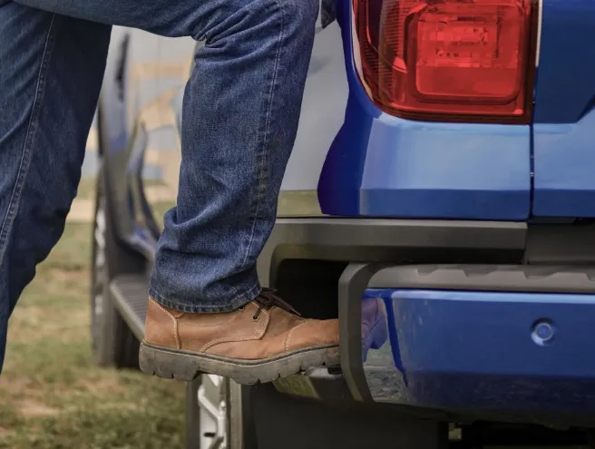 Pessoa a subir para a caixa traseira através do degrau que existe na Ford Ranger