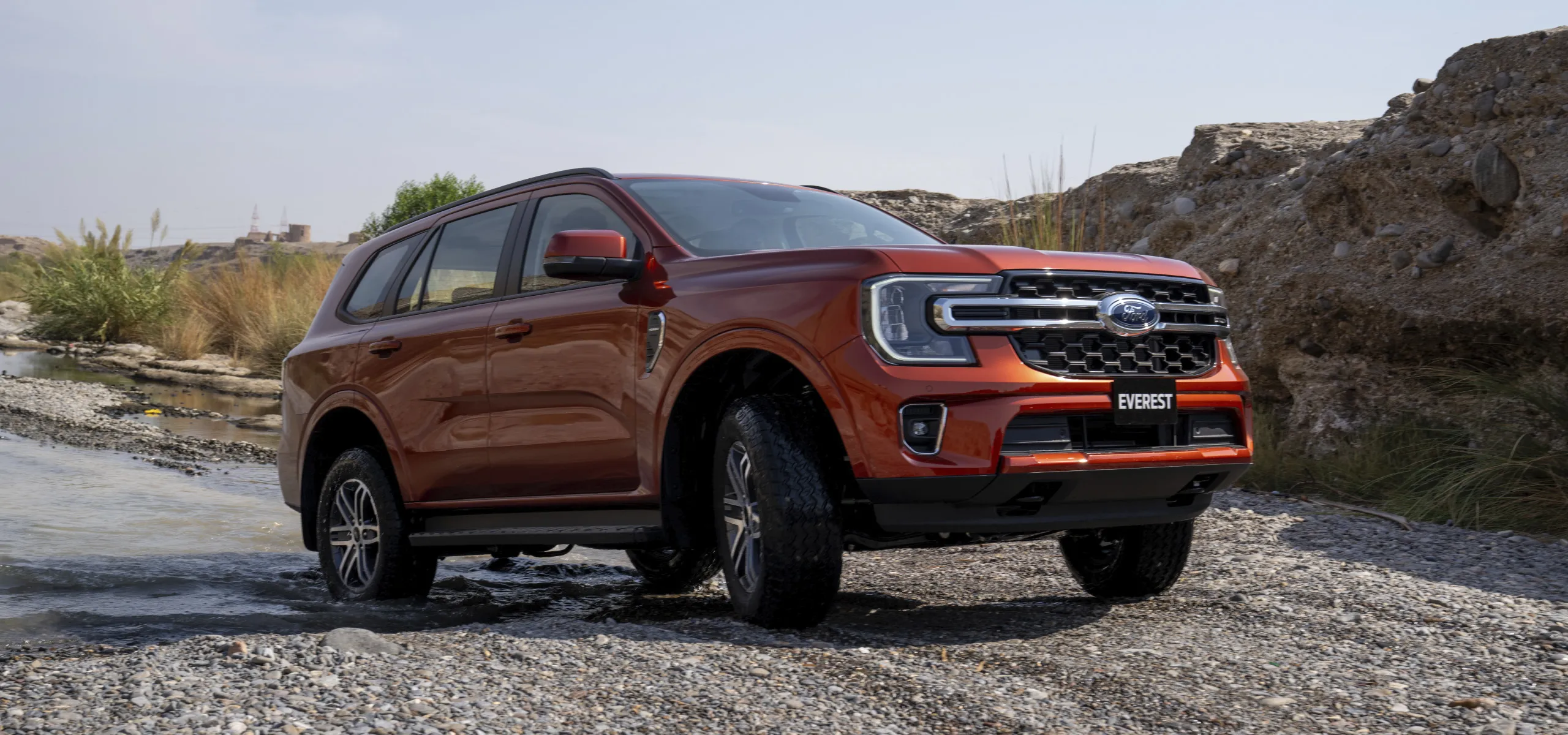Ford Everest quittant un lac et s'engageant sur un chemin de terre